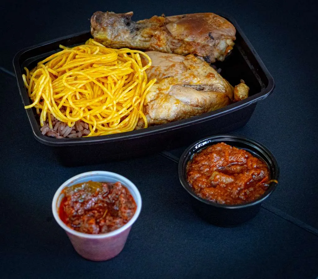 Ayimolou with rice, beans, chicken, and sides